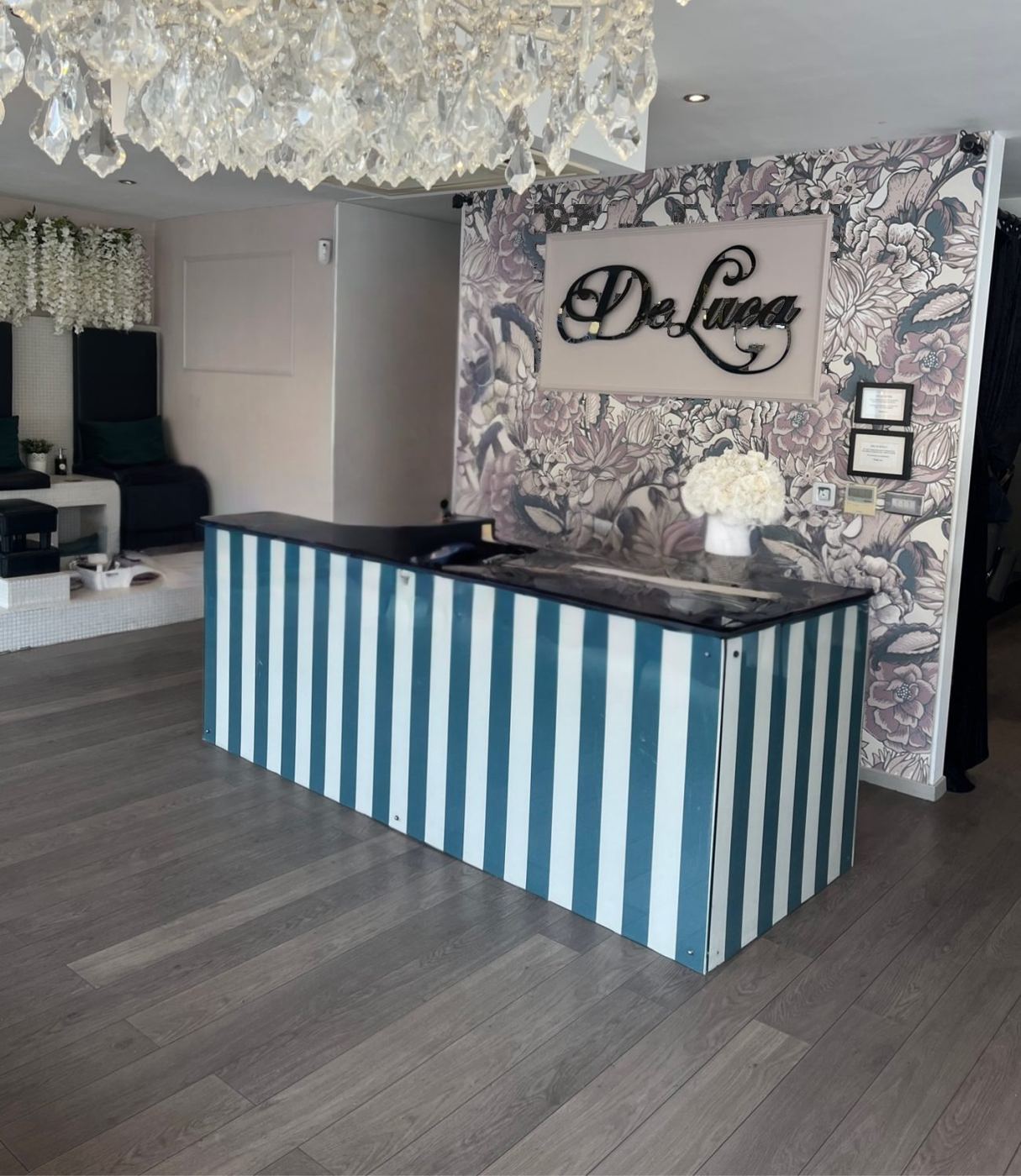 The reception desk and floral feature wall at De Luca Beauty